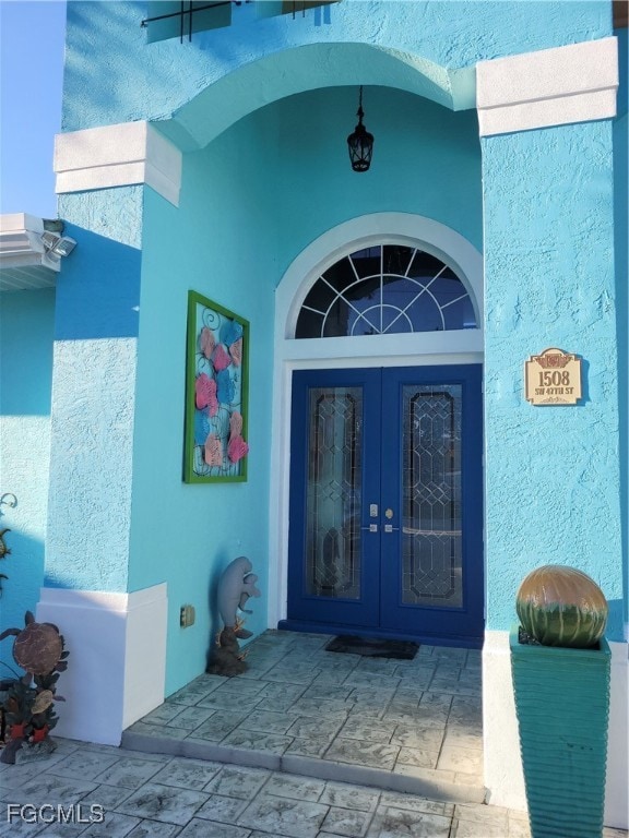 Doorway to property with french doors and stucco siding