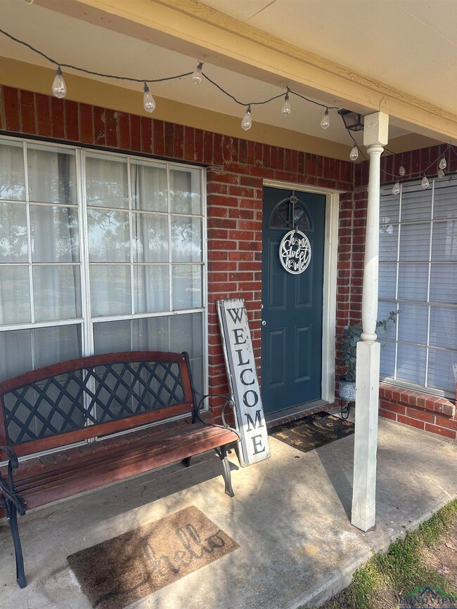 View of exterior entry with brick siding and a por