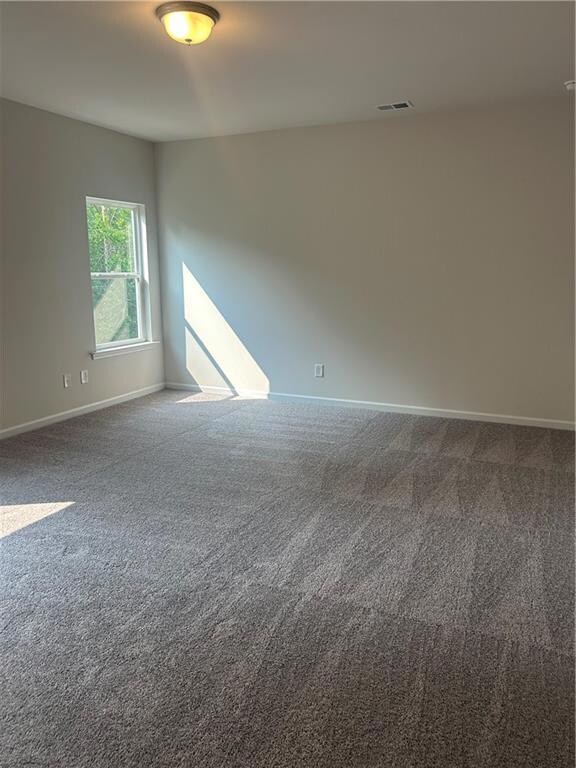Carpeted spare room with baseboards