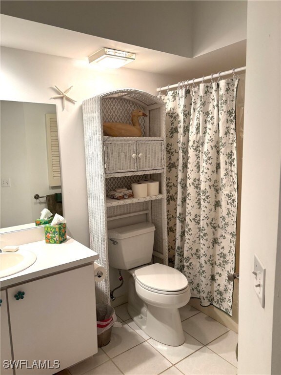 Full bathroom with light tile patterned flooring, vanity, and a shower with shower curtain