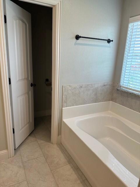 Bathroom with a bath to relax in and tile floors