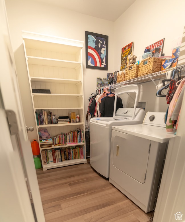 Washroom featuring washing machine and clothes dryer and light wood-style flooring