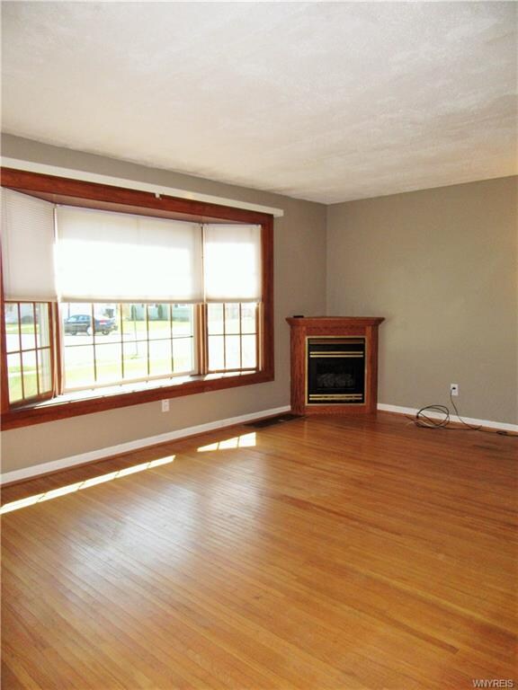 Living room with hardwood flooring and gas firepla