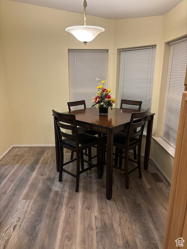 Dining room featuring dark wood-style floors and baseboards