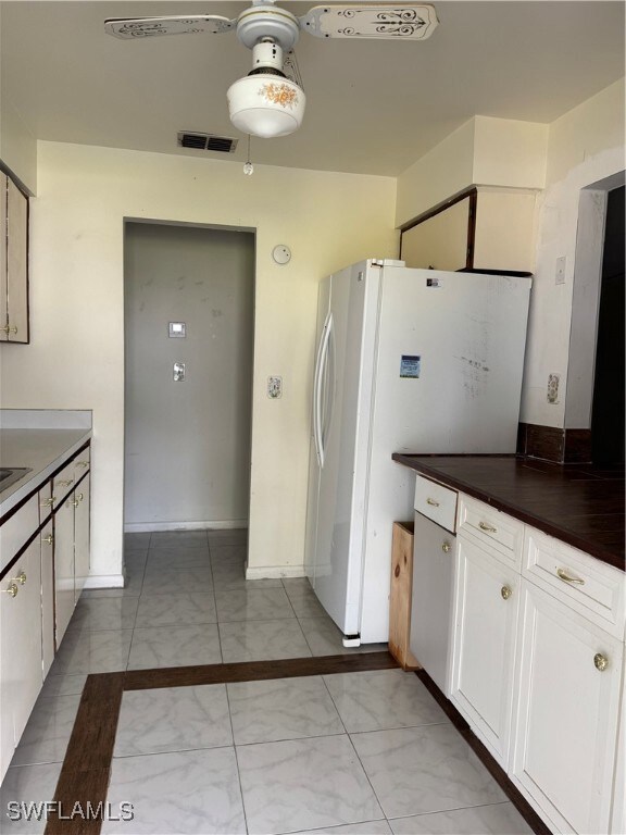 Kitchen featuring freestanding refrigerator, dark