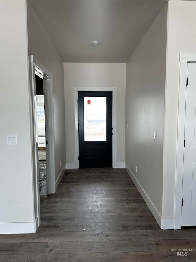 Foyer entrance with baseboards and dark wood-style flooring