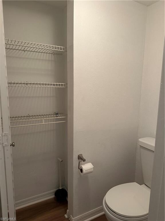 Bathroom with hardwood / wood-style floors and toilet