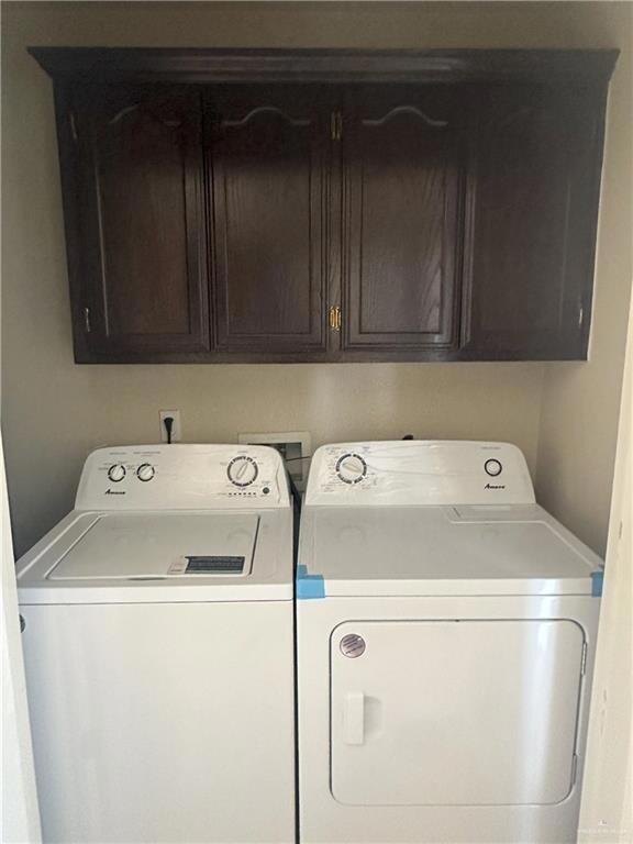 Laundry room featuring cabinets and washing machine and dryer