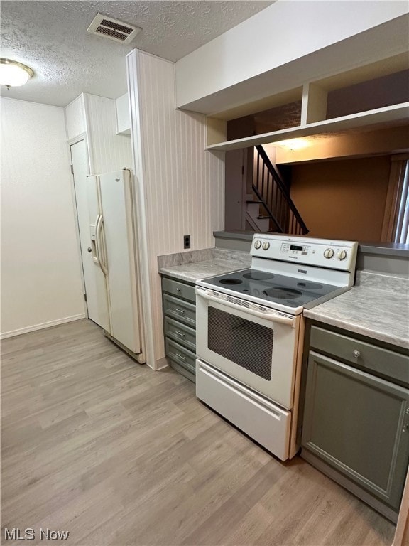 Kitchen featuring white appliances, gray cabinets, and light hardwood / wood-style flooring