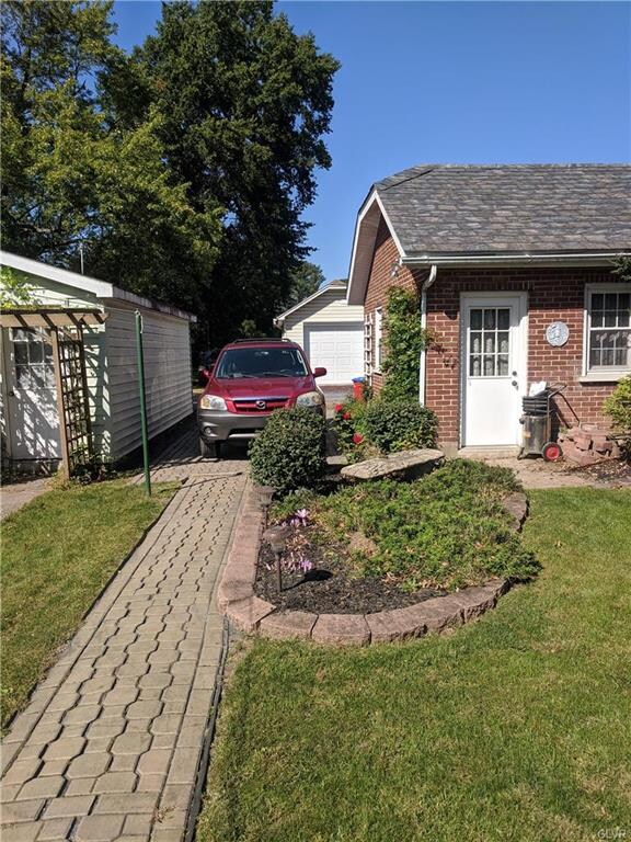 Brick paver walkway runs the length of the yard, l