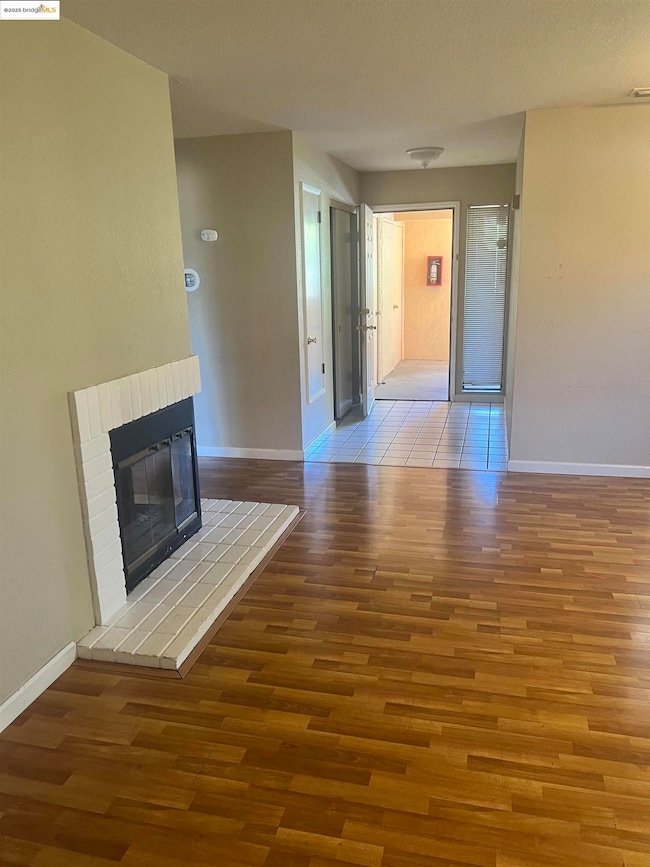 Unfurnished living room with wood finished floors and a fireplace