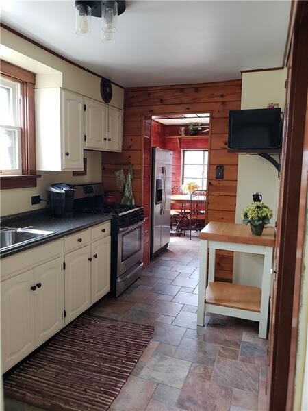White cabinets and ceramic flooring in updated kit