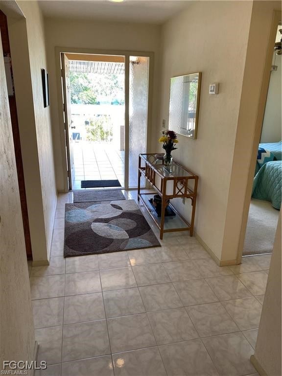 Entryway featuring light tile patterned floors and baseboards
