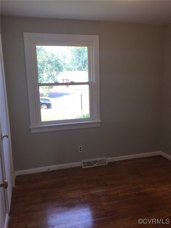 Unfurnished room with dark wood-style flooring and