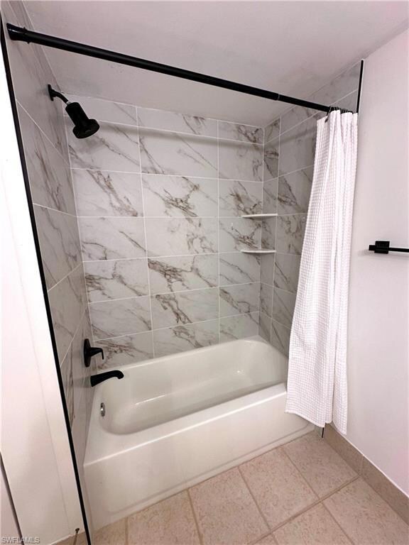 Bathroom with baseboards and shower / bath combina