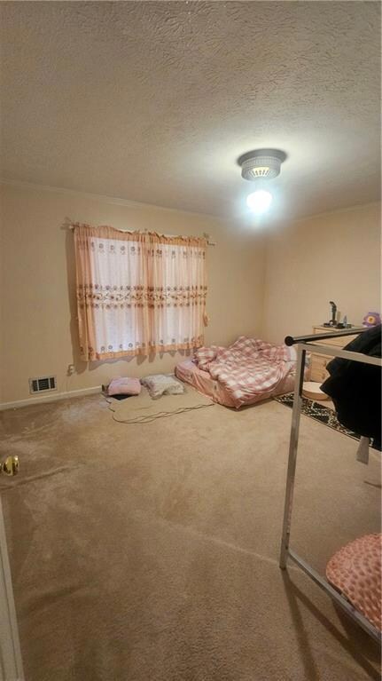 Carpeted bedroom with a textured ceiling and baseboards