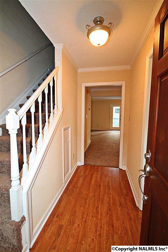 NEW LAMINATE FLOORING WARMS AT THE FOYER AND CONTINUES INTO THE KITCHEN.