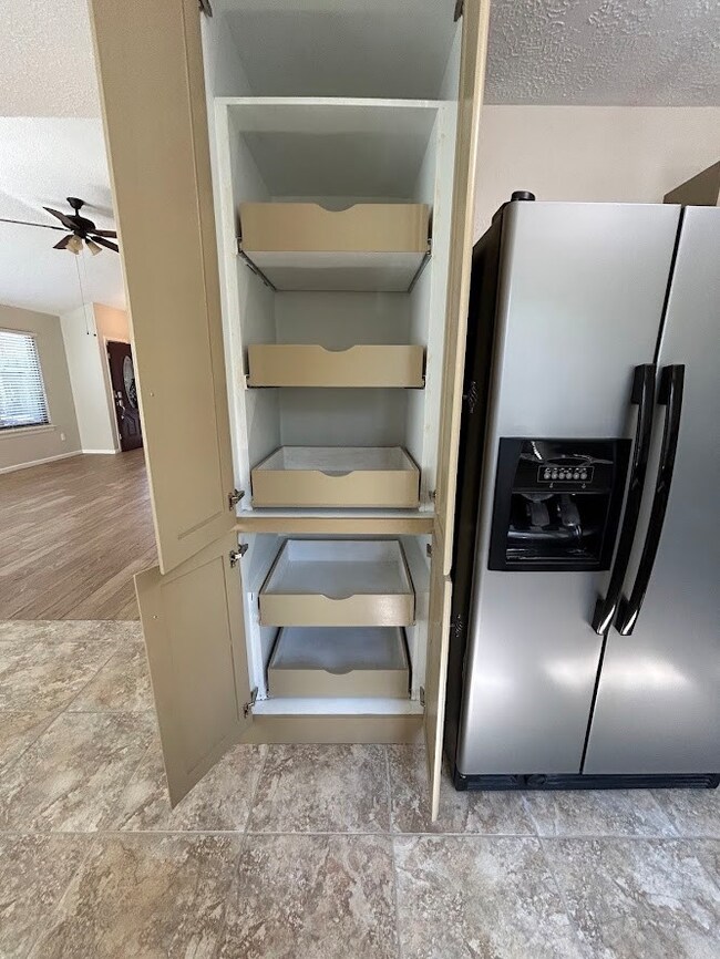 Look at this spacious pull-out shelving next to a stainless steel refrigerator. Ideal for organization.