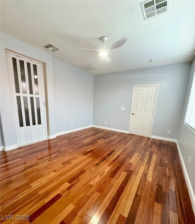 Empty room featuring a ceiling fan and hardwood /
