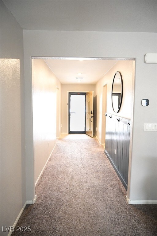 Corridor with baseboards and carpet