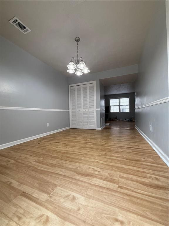 Unfurnished dining area with a chandelier and light wood finished floors