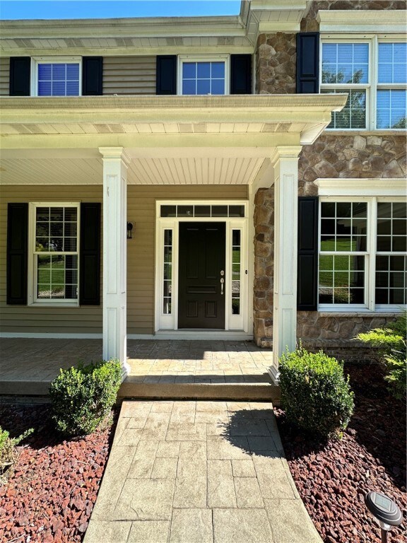A welcoming wrap around front porch with stamped c