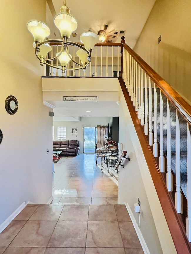 Stairway featuring a chandelier, tile patterned fl