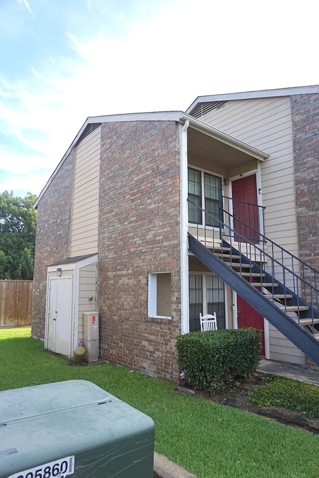 View of side of property with stairs and brick siding