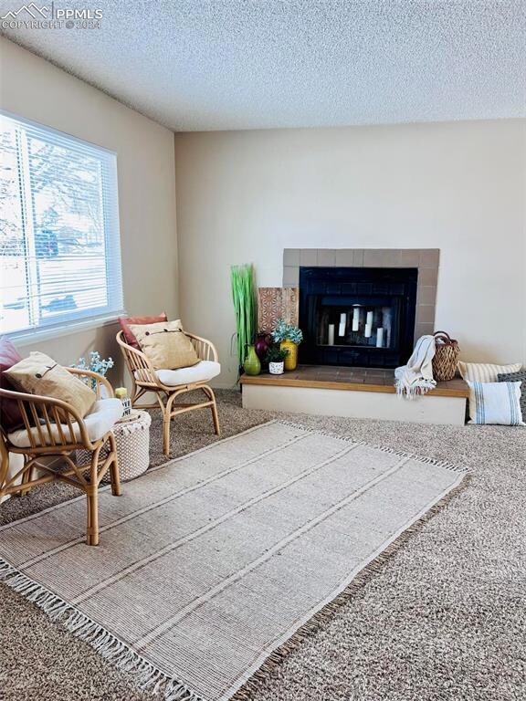 Carpeted living room with a tiled fireplace