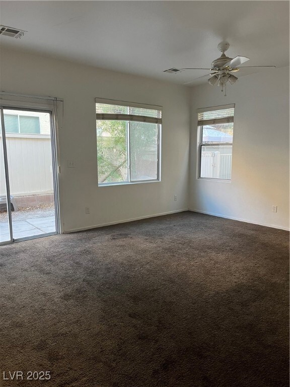 Carpeted spare room featuring baseboards and a ceiling fan