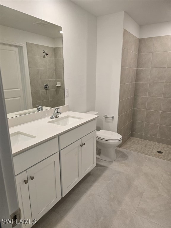 Bathroom with a tile shower, double vanity, a sink