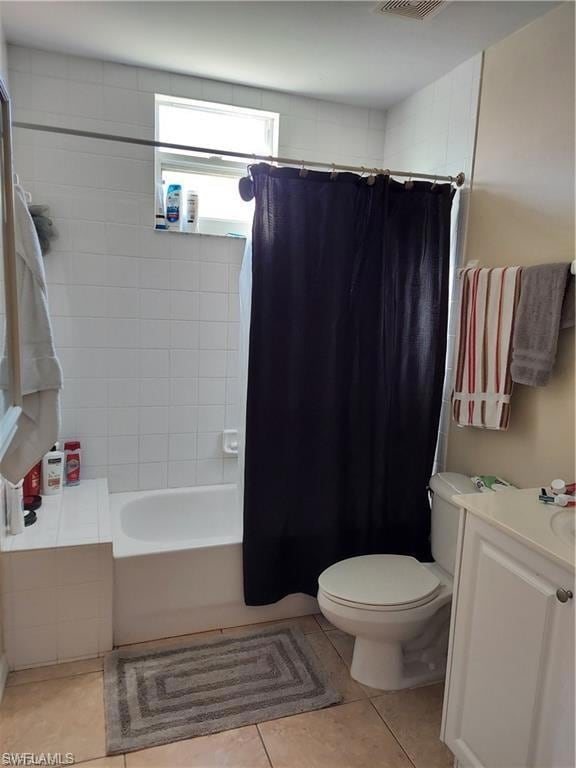 Full bathroom featuring vanity, tile patterned floors, shower / tub combo, and toilet