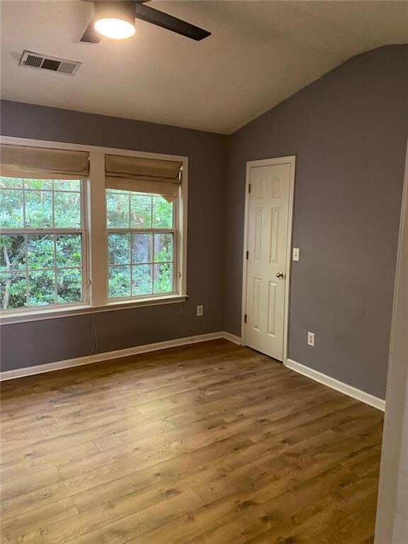 Unfurnished room with wood finished floors, ceiling fan, and vaulted ceiling