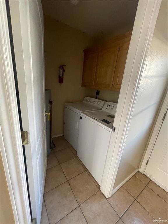 Laundry area featuring cabinets, washer and dryer, and light tile patterned flooring