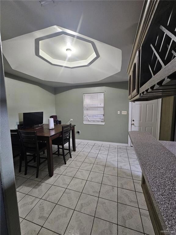 Tiled dining space with a raised ceiling