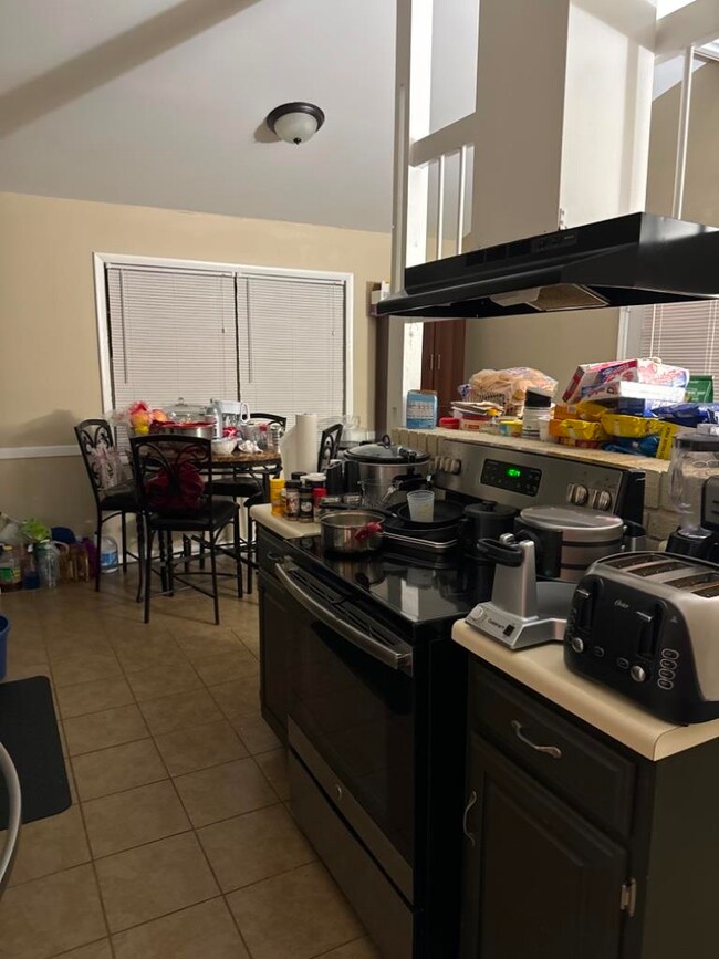 Kitchen featuring electric range oven, light tile 