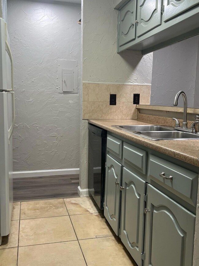 Kitchen featuring fridge, dishwasher, light tile p