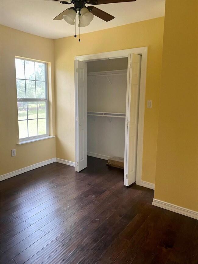 Unfurnished bedroom featuring dark wood-style flo