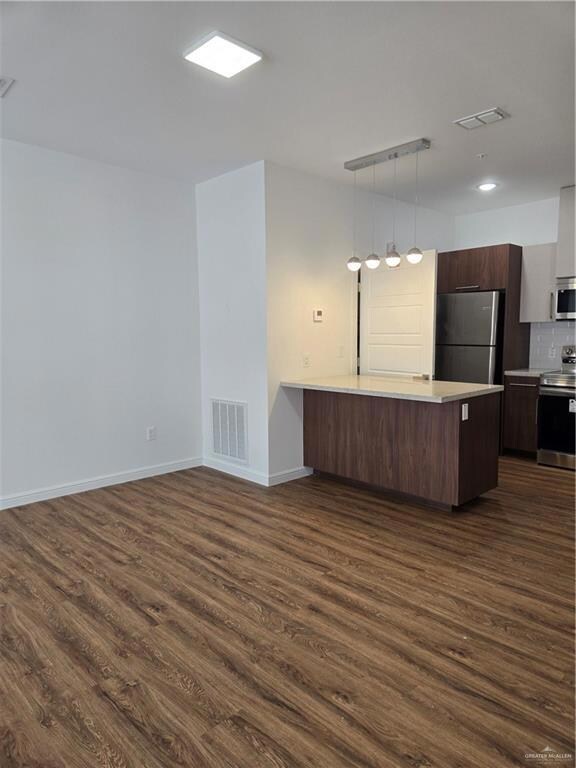 Kitchen with visible vents, light countertops, range, and refrigerator
