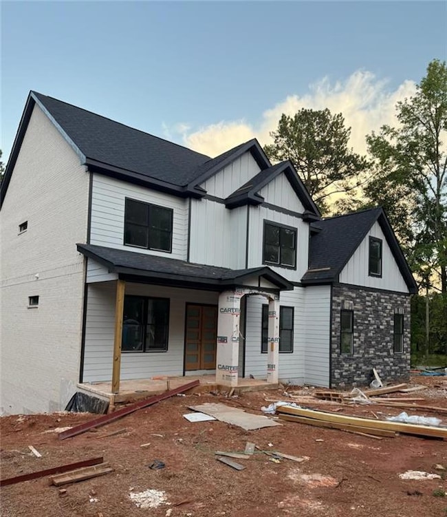 Modern farmhouse with covered porch, board and batten siding, and a shingled roof