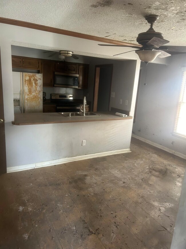 Kitchen with a textured ceiling, sink, ceiling fan