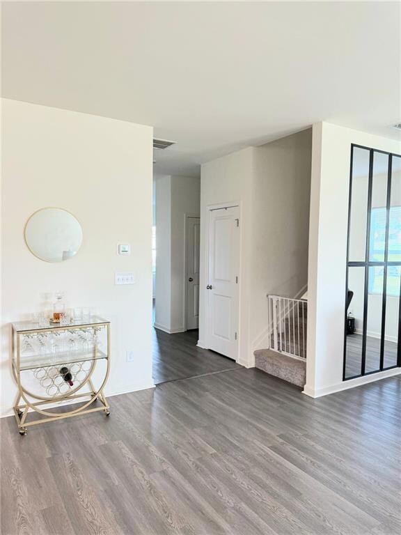 Spare room with wood finished floors, stairway, and baseboards