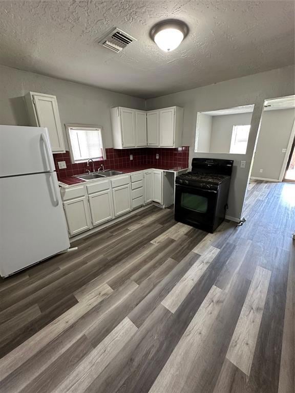 Kitchen featuring refrigerator, range, a sink, a t