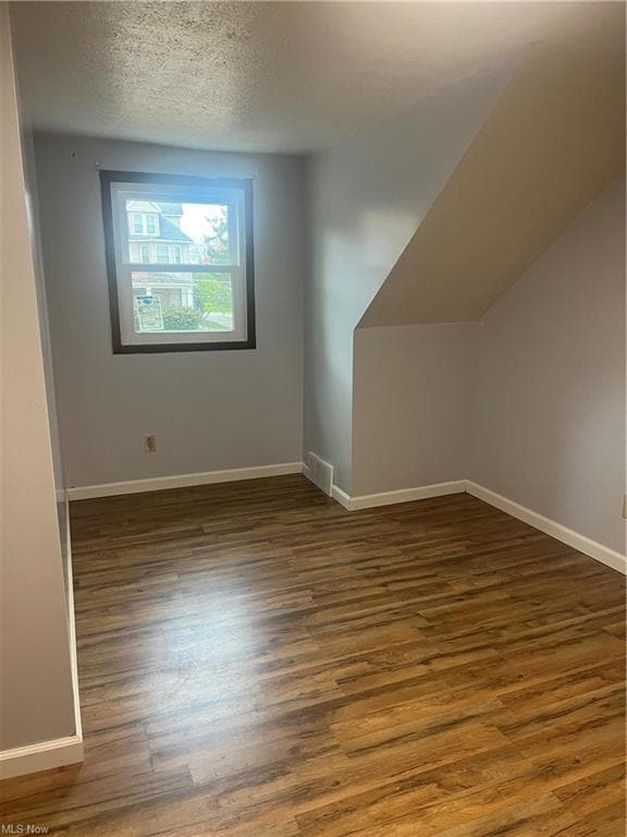 Bonus room featuring dark hardwood / wood-style fl