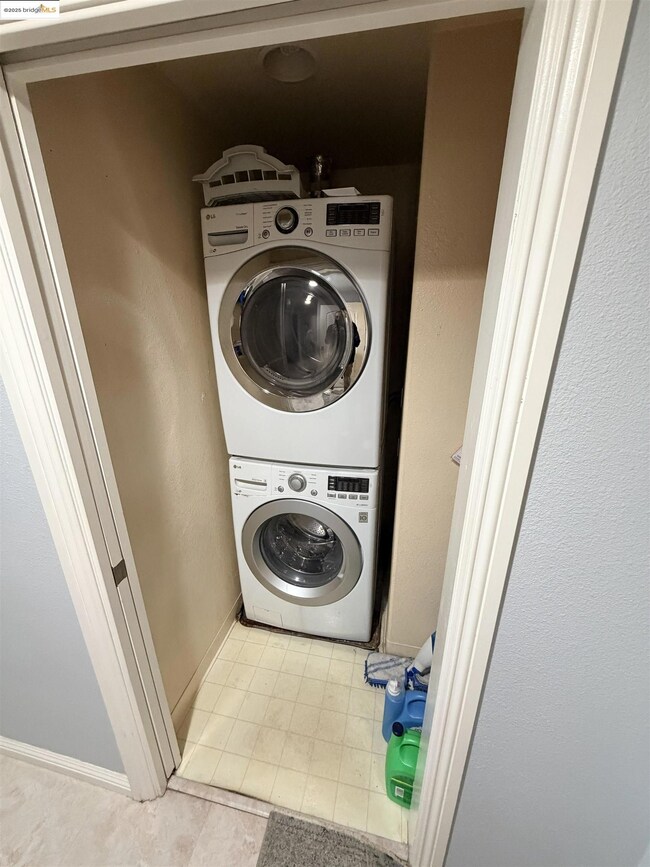 Laundry area with stacked washer / dryer and baseboards