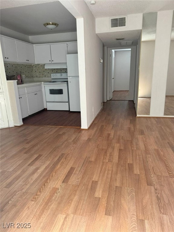 Kitchen with white appliances, light wood-style fl