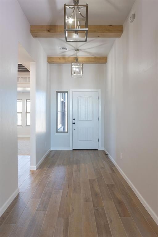 Entrance foyer with beam ceiling, a chandelier, an