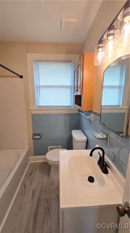 Bathroom with toilet, vanity, wood finished floors