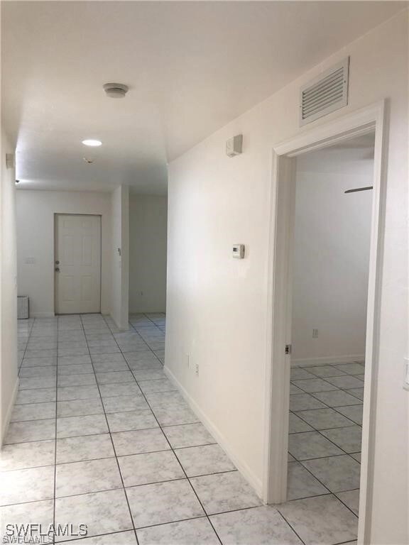 Hallway featuring light tile patterned flooring an