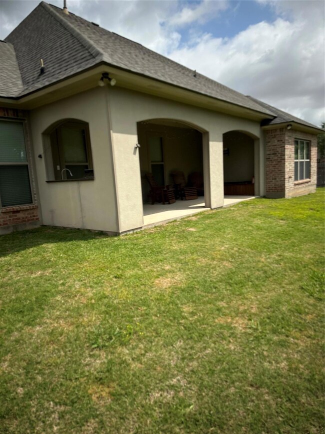 Back of property featuring a yard
